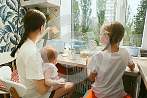 The happy smiling caucasian family in the kitchen preparing breakfast