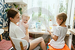 The happy smiling caucasian family in the kitchen preparing breakfast