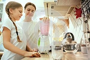 The happy smiling caucasian family in the kitchen preparing breakfast