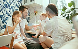 The happy smiling caucasian family in the kitchen preparing breakfast