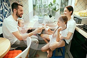 The happy smiling caucasian family in the kitchen preparing breakfast