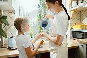 The happy smiling caucasian family in the kitchen preparing breakfast