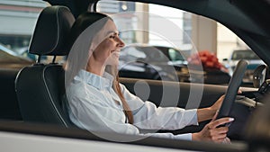 Happy smiling Caucasian female driver inside car choosing automobile in salon woman girl lady smile enjoy sitting in