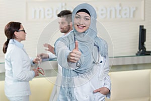 Happy smiling cheerful female muslim doctor with thumbs up gesture