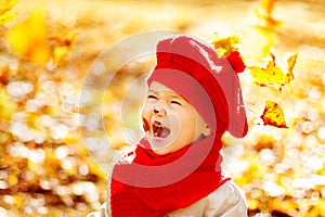 Happy smiling child in autumn park, fall yellow leaves