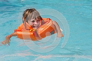 Happy smiling child girl in inflatable life-jacket