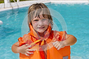 Happy smiling child girl in inflatable life-jacket