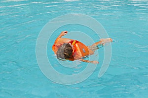 Happy smiling child girl in inflatable life-jacket