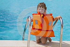 Happy smiling child girl in inflatable life-jacket