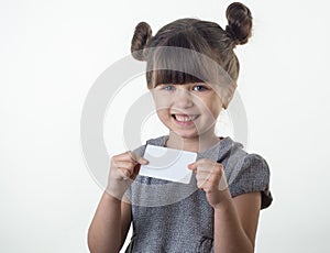 Happy smiling child holding discount white card in her hands. Kid with credit card.