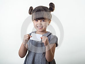 Happy smiling child holding discount white card in her hands. Kid with credit card