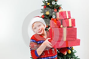 Happy smiling child holding pile of present boxes