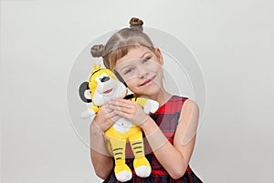 Happy and smiling child hugging tiger toy on white background