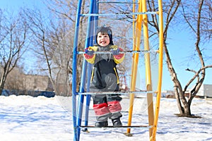 Happy smiling child in overall plays in winter
