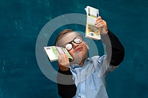 Happy smiling child wearing eyeglasses with cash