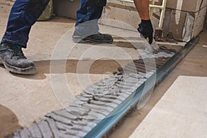 Happy smiling construction worker constructing or building wall by placing bricks and cement - concept of hard working, manual