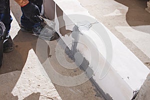 Happy smiling construction worker constructing or building wall by placing bricks and cement - concept of hard working, manual photo