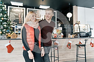 Happy smiling couple embracing in coffee shop in winter season