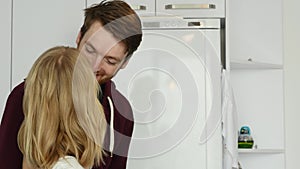 Happy smiling couple kissing and hugging in kitchen in love