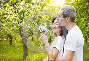 Happy smiling couple in love in bloomy garden