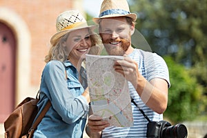 happy smiling couple with map in city