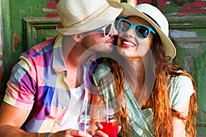 Happy smiling couple in sunglass and hat with guitar drinking j