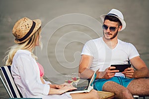 Happy smiling couple surfing the net and enjoy the summer at beach