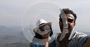Happy Smiling Couple Taking Selfie Photo On Mountain Top Over Beautiful Landscape POV, Mix Race Man And Woman Tourists