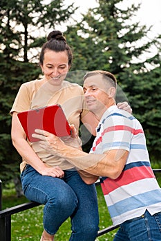 Happy smiling couple using a digital tablet outdoors
