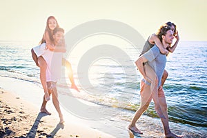 Happy smiling couples playing at the beach