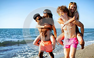 Happy smiling couples playing at the beach