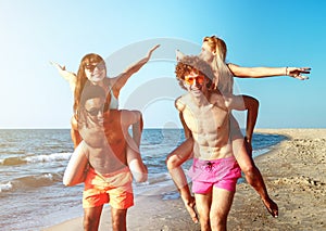 Happy smiling couples playing at the beach