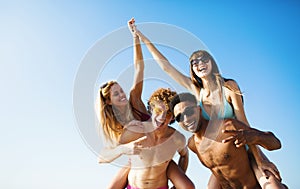 Happy smiling couples playing at the beach