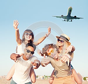 Happy smiling couples playing at the beach with aircraft in the sky
