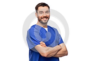 happy smiling doctor or male nurse in blue uniform