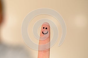 Happy smiling face hand drawn on a finger tip