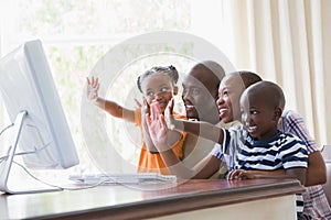Happy smiling family chatting with computer together