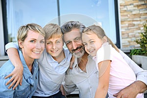 Happy smiling family in front of their new home