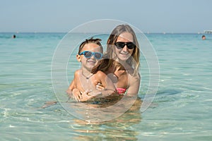 Happy smiling family having fun on tropical white beach Maldives islands. Mother and cute son. Positive human emotions, feelings