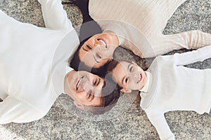 Top view.Happy smiling family hugging while lying on the floor in the room at home. C