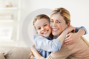 Happy smiling family hugging on sofa at home