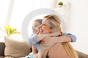 Happy smiling family hugging on sofa at home