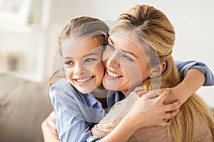 Happy smiling family hugging on sofa at home