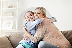 Happy smiling family hugging on sofa at home
