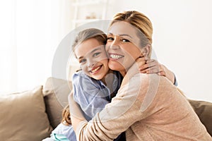 Happy smiling family hugging on sofa at home