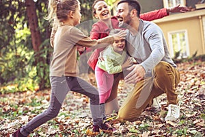 Happy smiling family running and playing at backyard.