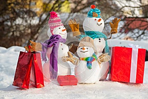 Happy smiling family snowman - sale discount concept. Funny group of snowmen family hold Christmas gift. Delivery gifts