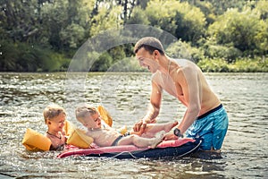 Happy smiling father playing kids sons swimming lifestyle portrait concept happy paternity and childhood during summer holidays. photo