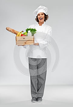 Happy smiling female chef with food in wooden box