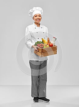 happy smiling female chef with food in wooden box